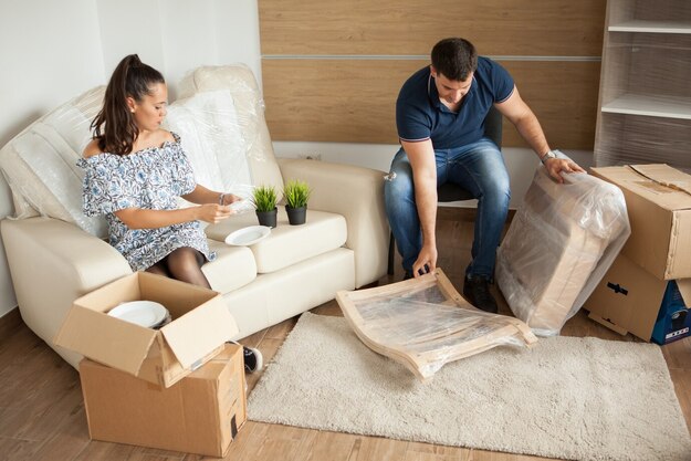 https://jlmovers.com.au/wp-content/uploads/2025/01/young-couple-moving-new-home-unpacking-carboard-boxes-almost-done-moving_482257-24142-1.jpg